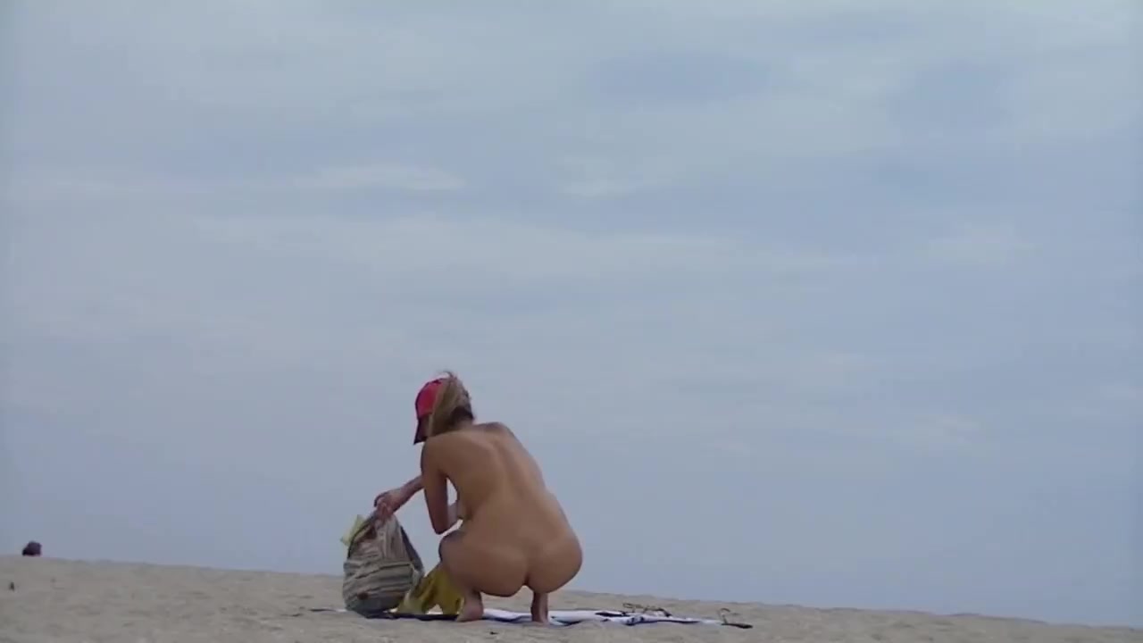 En ensam tjej är naken på stranden